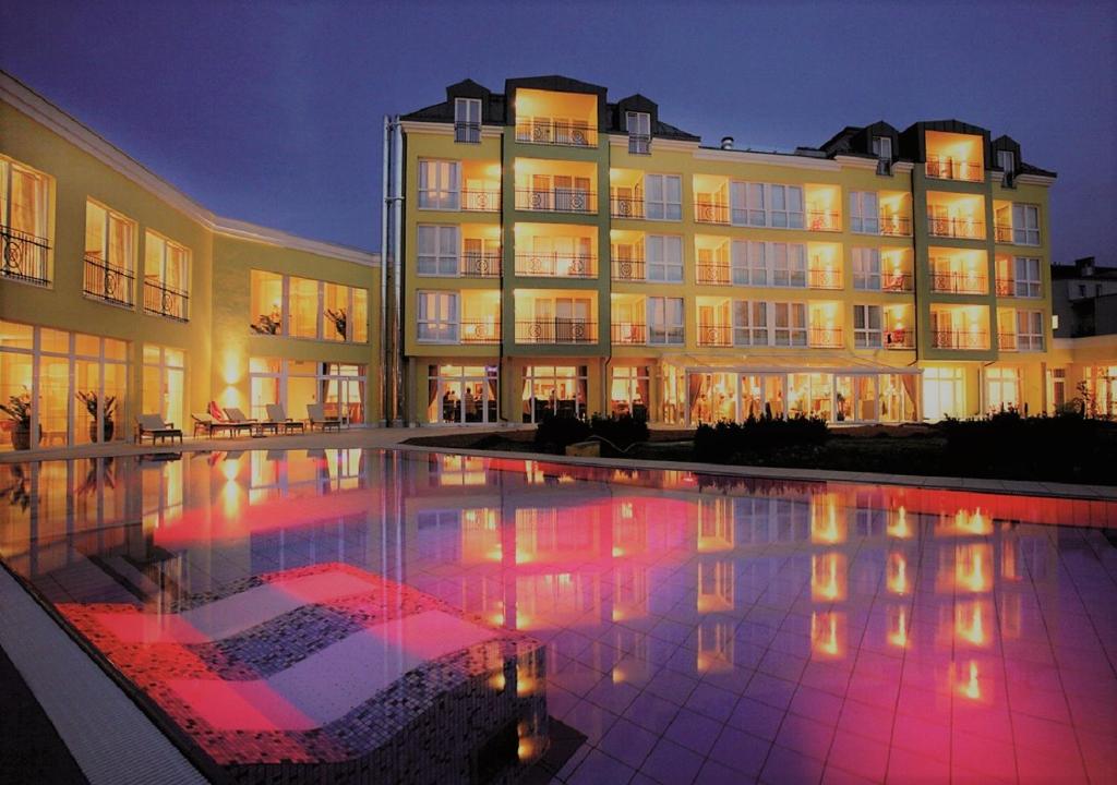 - un grand bâtiment avec une piscine en face dans l'établissement Parkhotel, à Bad Schallerbach
