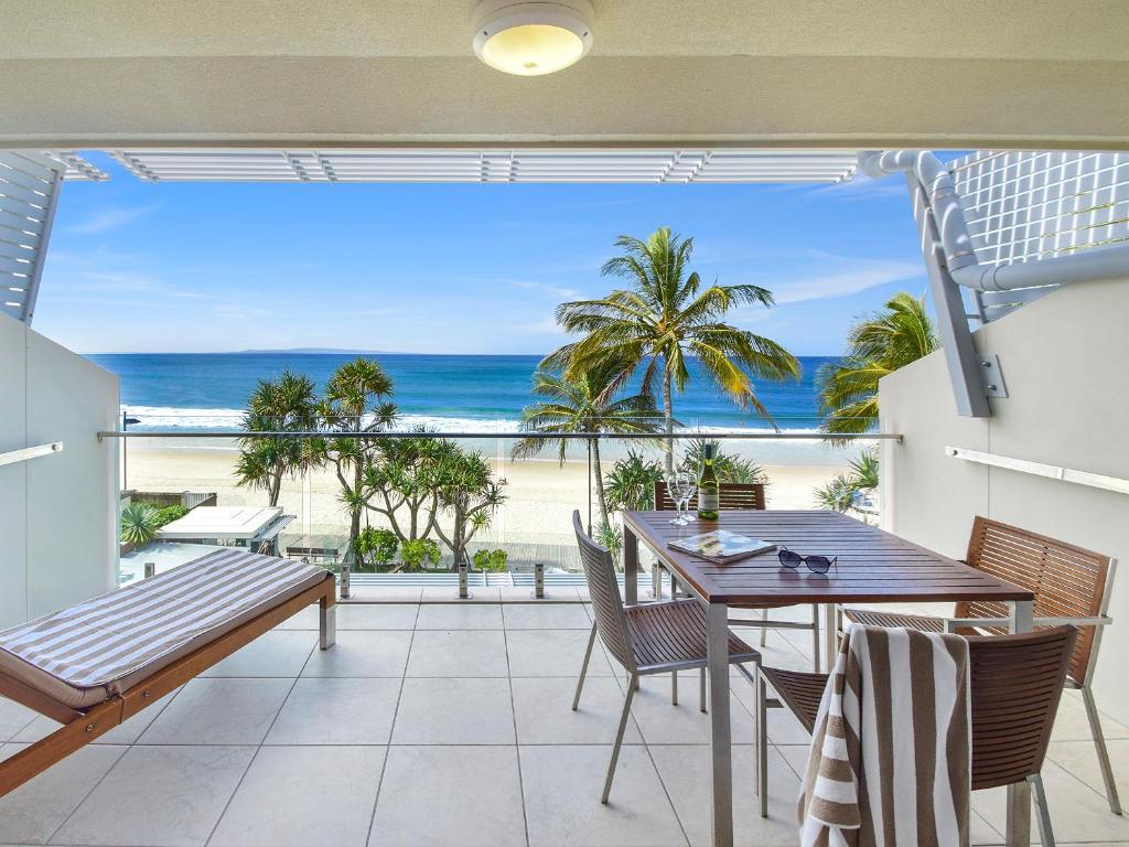 a dining room with a table and a view of the beach at Fairshore Noosa in Noosa Heads