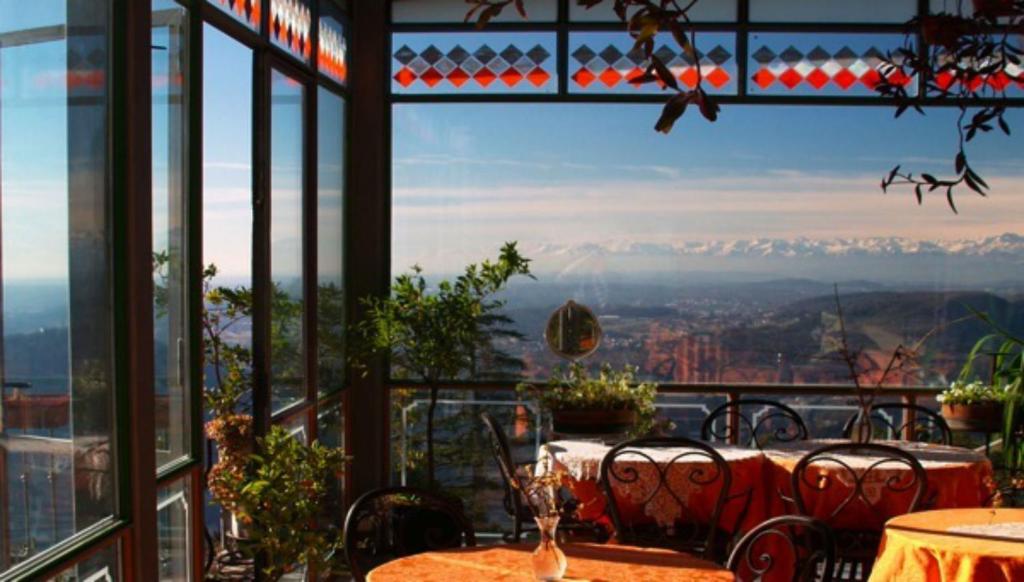 ブルナーテにあるベッラヴィスタ ブティック ホテルのテーブルと椅子付きのレストランから山々の景色を望めます。