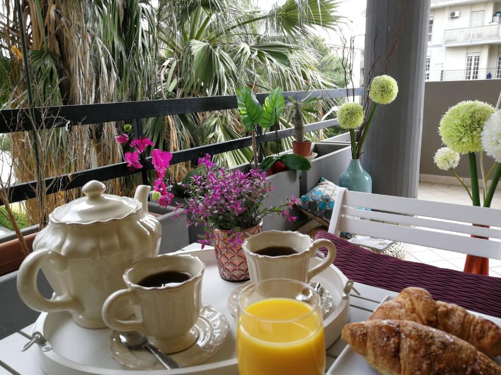 uma mesa com 2 chávenas de café e uma chaleira de chá em Cagliari Family Apartment em Cagliari