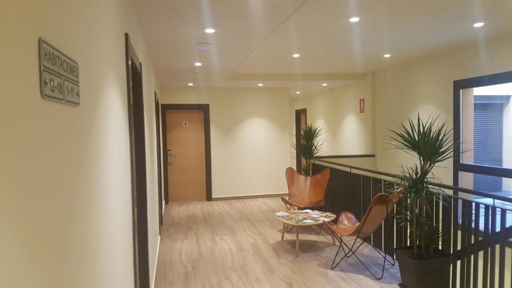 un pasillo con una escalera con sillas y una mesa en Hotel Hormilla en Hormilla