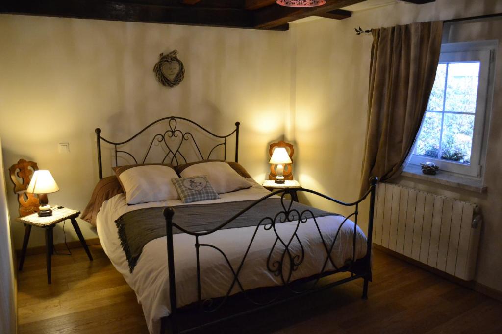 a bedroom with a bed and two lamps and a window at Chambres d'Hôtes S'burehiesel in Schillersdorf