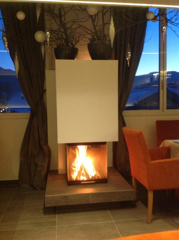 a fireplace in a living room with a fire at Der Winklhof in Saalfelden am Steinernen Meer