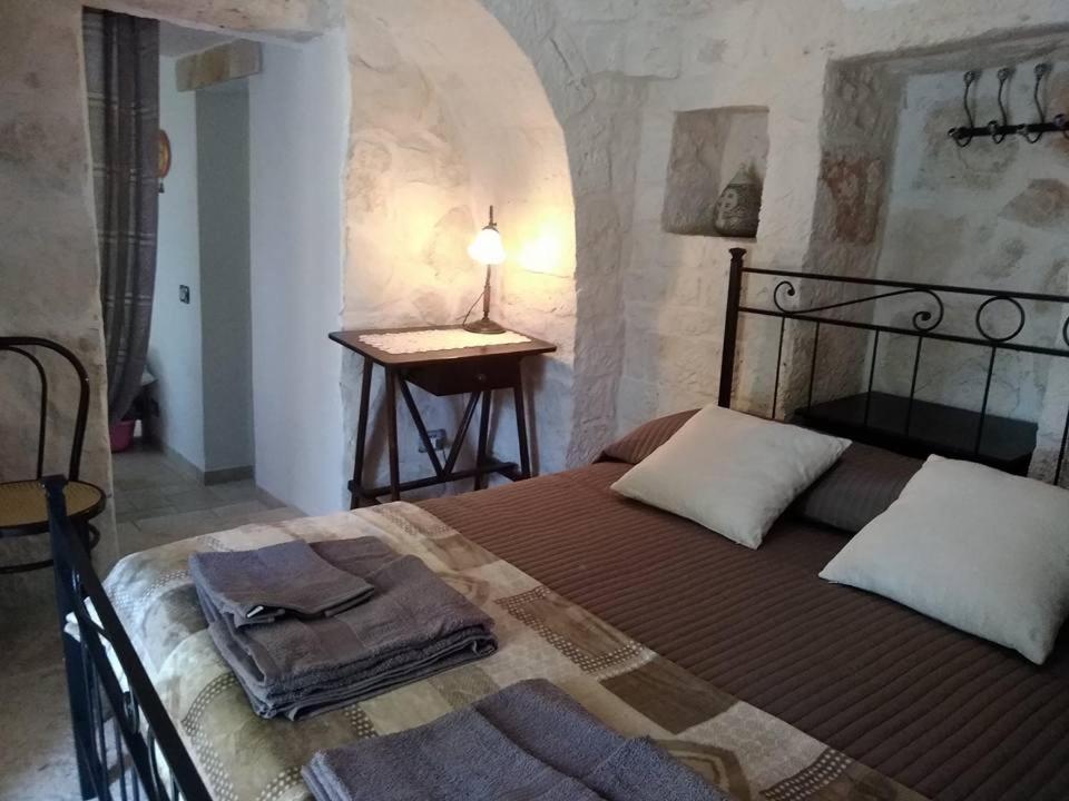 1 dormitorio con 1 cama con toallas en Trulli Villa Gloria en Alberobello