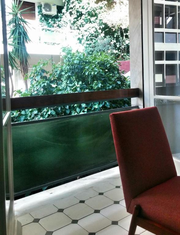 czerwone krzesło na balkonie z oknem w obiekcie Central new Kolonaki apartment w Atenach