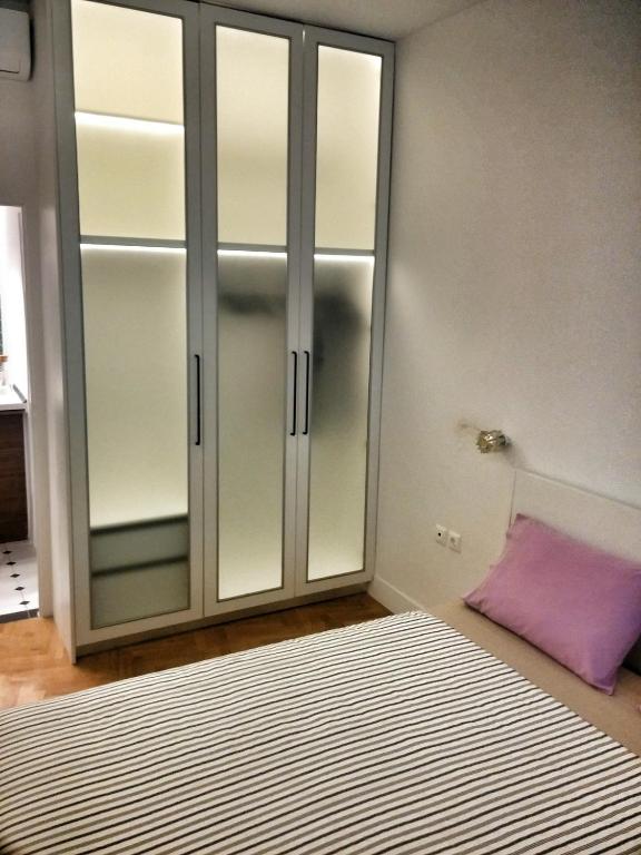 sypialnia z przeszkloną szafą i fioletową poduszką w obiekcie Central new Kolonaki apartment w Atenach