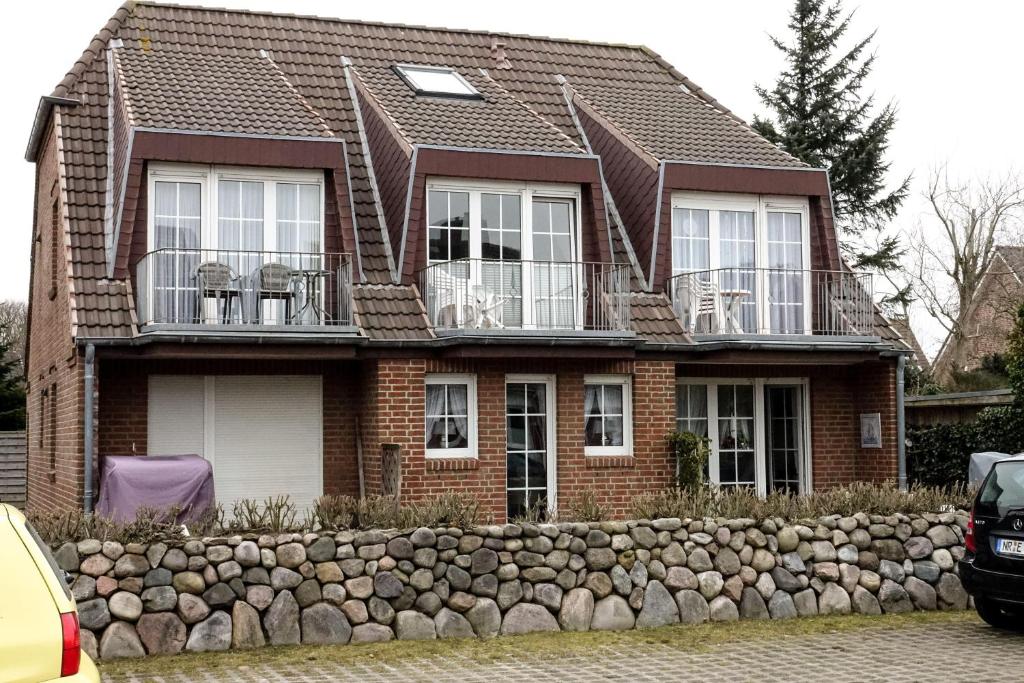 ein Backsteinhaus mit Fenstern und einer Felswand in der Unterkunft Wohnung Amsel, App. 4 in Westerland