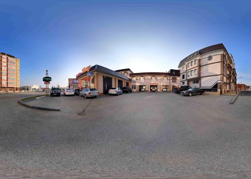 un aparcamiento con coches estacionados frente a los edificios en Hotel Nika, en Yessentuki