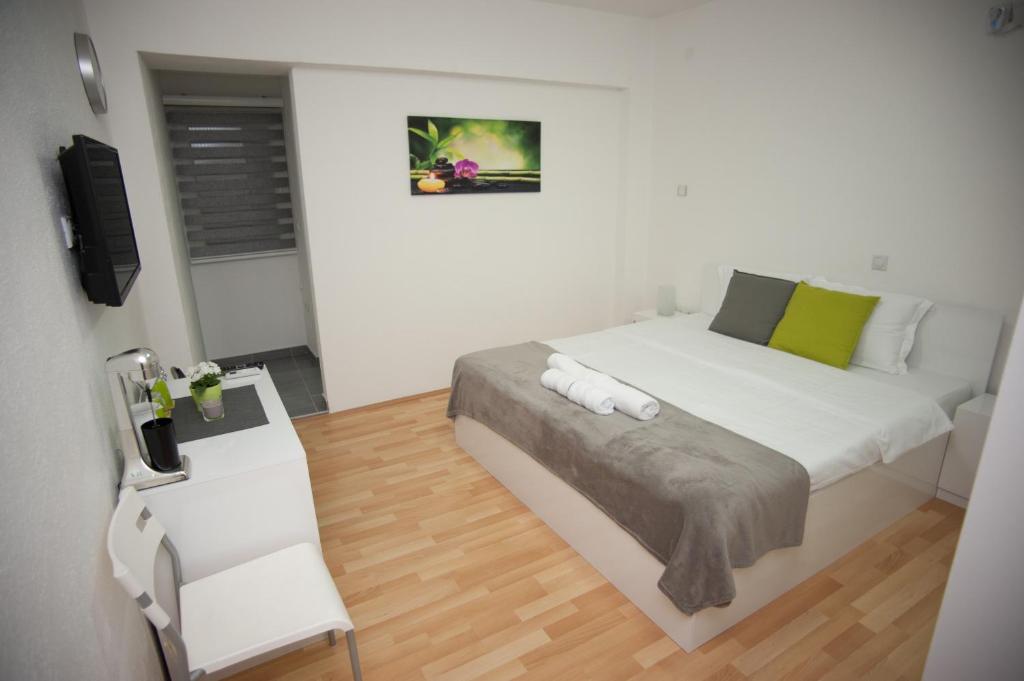 ein weißes Schlafzimmer mit einem Bett und einem Schreibtisch in der Unterkunft Vila Vanila in Gevgelija