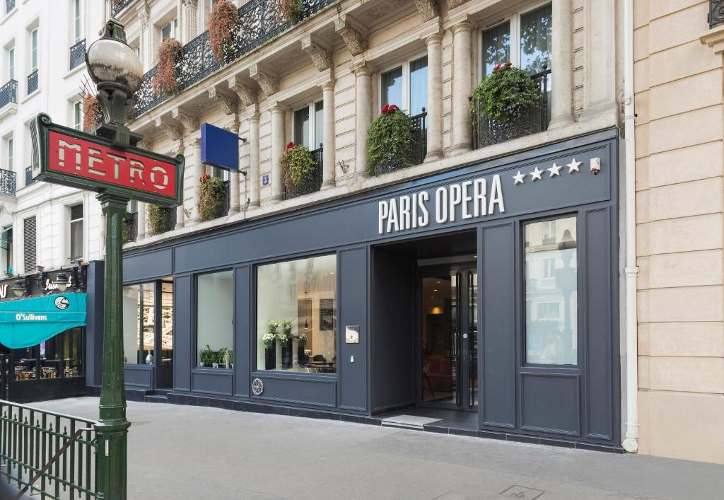 un magasin dans une rue avec un panneau devant lui dans l'établissement Hotel Paris Opera Affiliated by Meliá, à Paris