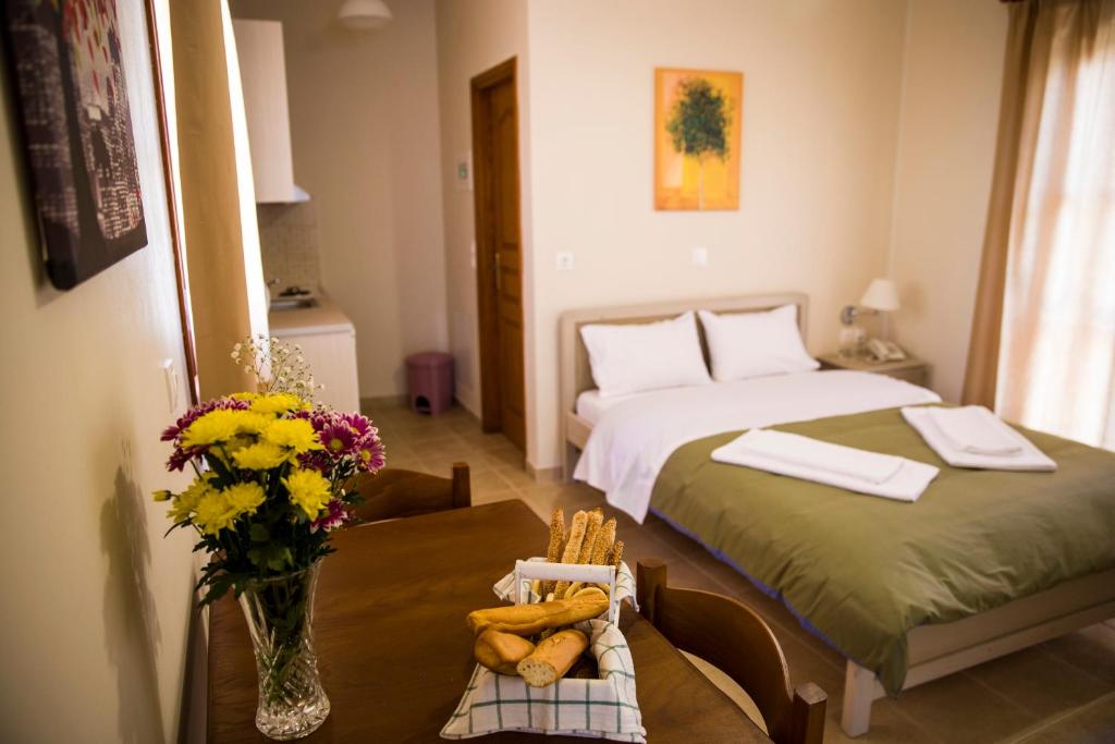 a bedroom with a bed and a table with flowers on it at Ellanion Studios in Aegina Town