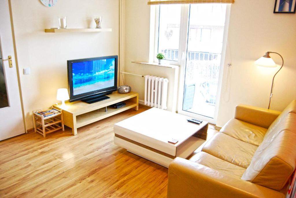 a living room with a couch and a tv at HelApart - Helium in Hel