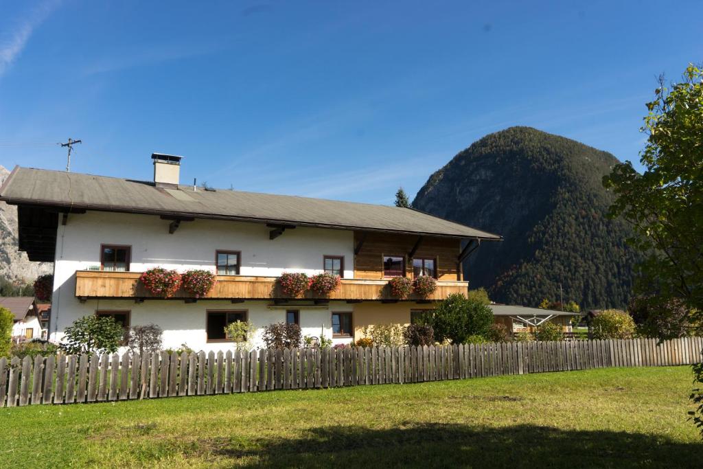 una casa blanca con una valla y una montaña en Landhaus Rauth, en Leutasch