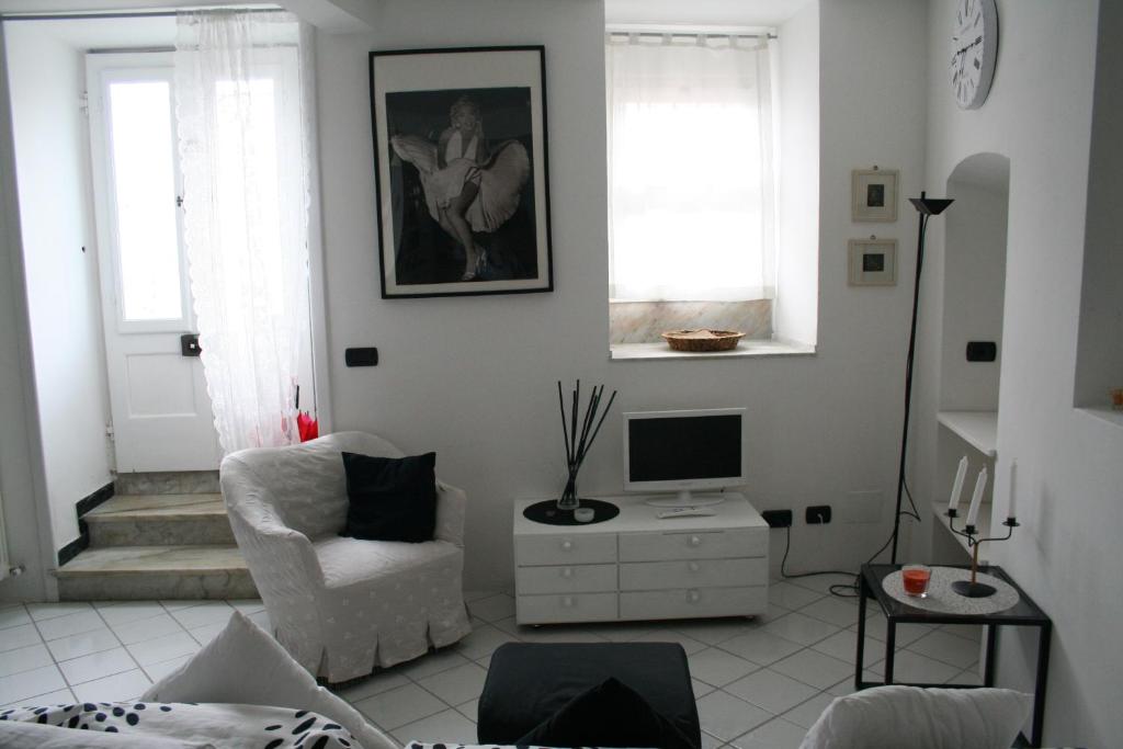 ein Wohnzimmer mit einem Stuhl und einem TV in der Unterkunft Casetta bianca sul mare in Bogliasco