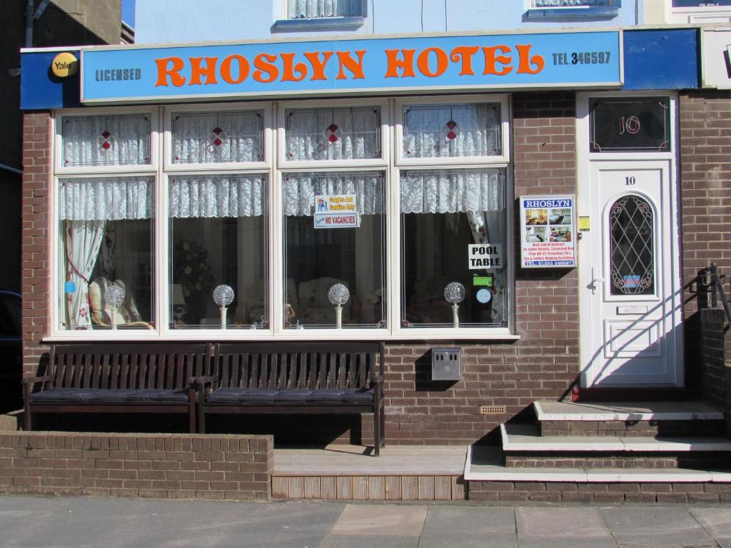 a brick hotel with a bench in front of it at Rhoslyn Hotel in Blackpool