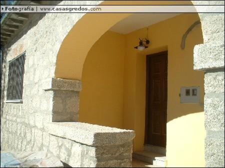 uma entrada para um edifício com uma porta castanha em Casa Rural los Portalillos I em Navatalgordo