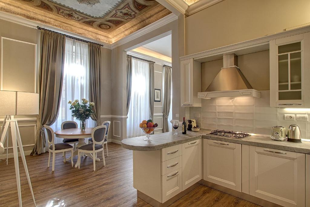 een keuken met witte kasten en een tafel en een eetkamer bij Art Apartment Luxury Family suite in Florence