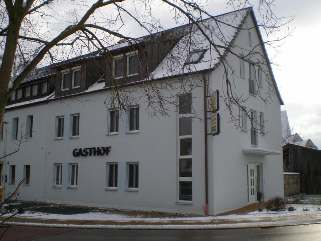 ein weißes Gebäude mit einem Schild an der Seite in der Unterkunft Gästehaus zur Kurve in Zirndorf