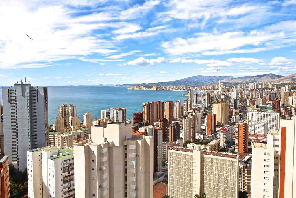 vistas a una ciudad con edificios y al océano en Residence Vacanza Torre Montecarlo, en Benidorm