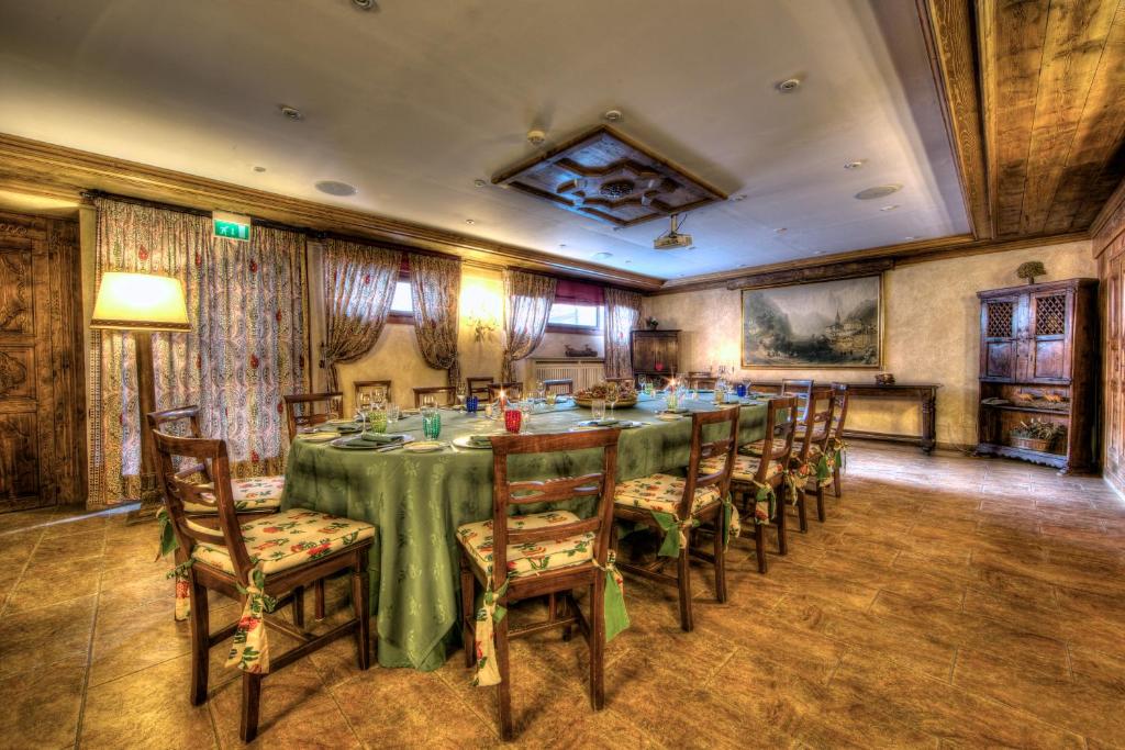 a dining room with a long table and chairs at Villa Novecento Romantic Hotel - Estella Hotel Collection & Experience in Courmayeur