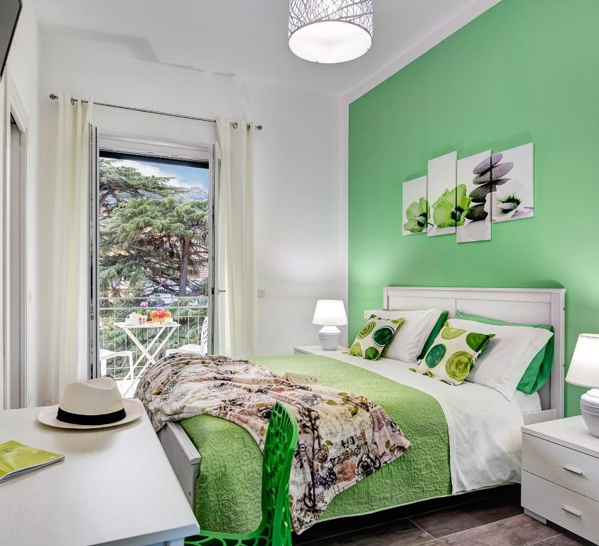 een groene slaapkamer met een bed en een raam bij I colori di Sorrento in Sorrento