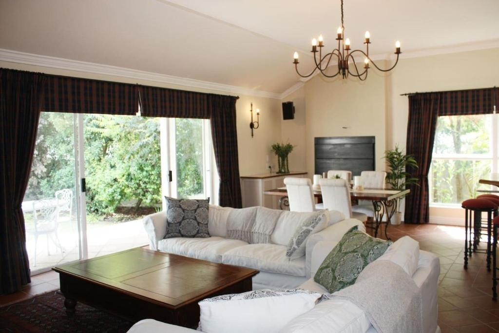 uma sala de estar com um sofá e uma mesa em Camelot in Constantia em Cidade do Cabo