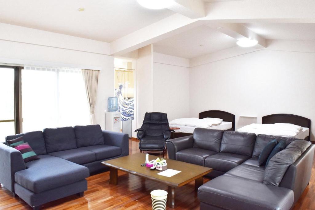 salon z kanapą i stołem w obiekcie Cottage Sachi w mieście Nakijin