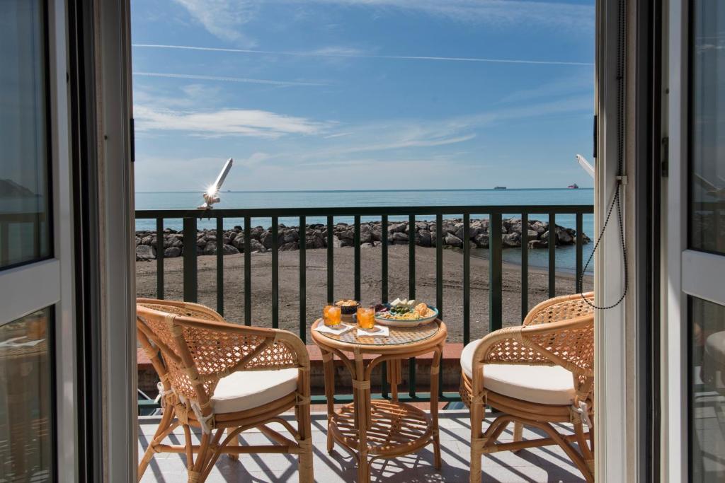 a balcony with a table and chairs with a view of the ocean at Mare mìa in Salerno