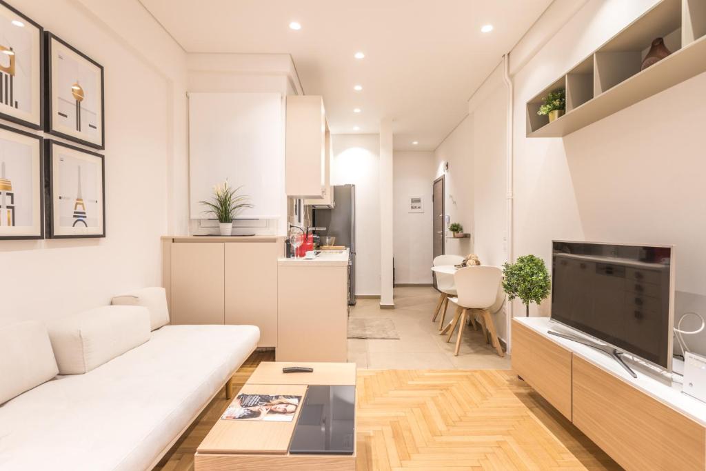 uma sala de estar com um sofá branco e uma cozinha em HiEnd 4th floor 1bdr em Atenas