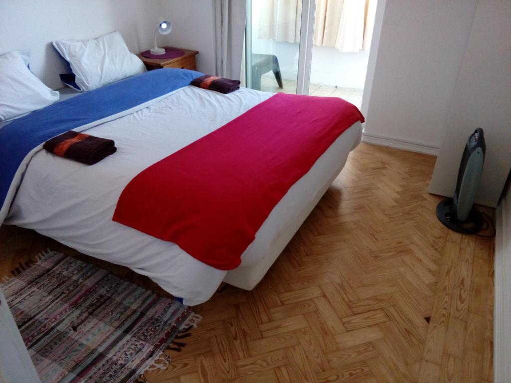a bedroom with a bed with a red white and blue blanket at Voyage 63 in Lisbon