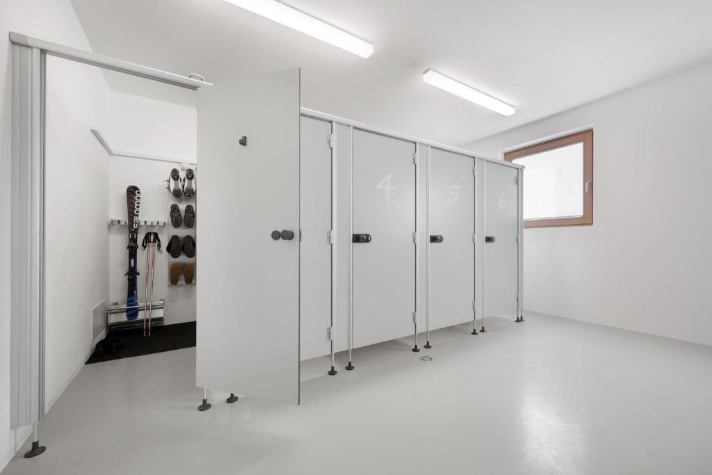 rząd białych szafek w białym pokoju w obiekcie Living Nature Appartements w mieście San Vigilio di Marebbe