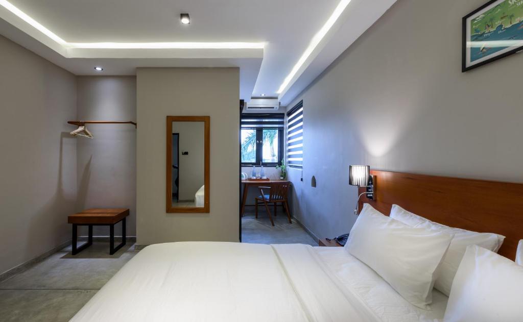 a bedroom with a large white bed and a desk at Fern Colombo in Colombo