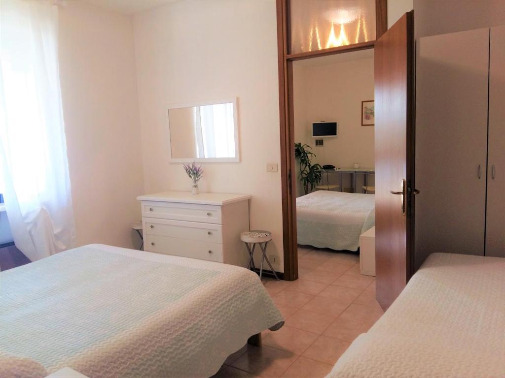 a bedroom with two beds and a mirror at Hotel La Rama in Lazise