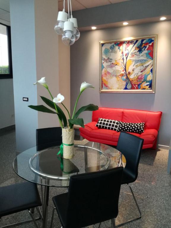 a living room with a red couch and a glass table at Hotel Baffo Rosso in Alba Adriatica
