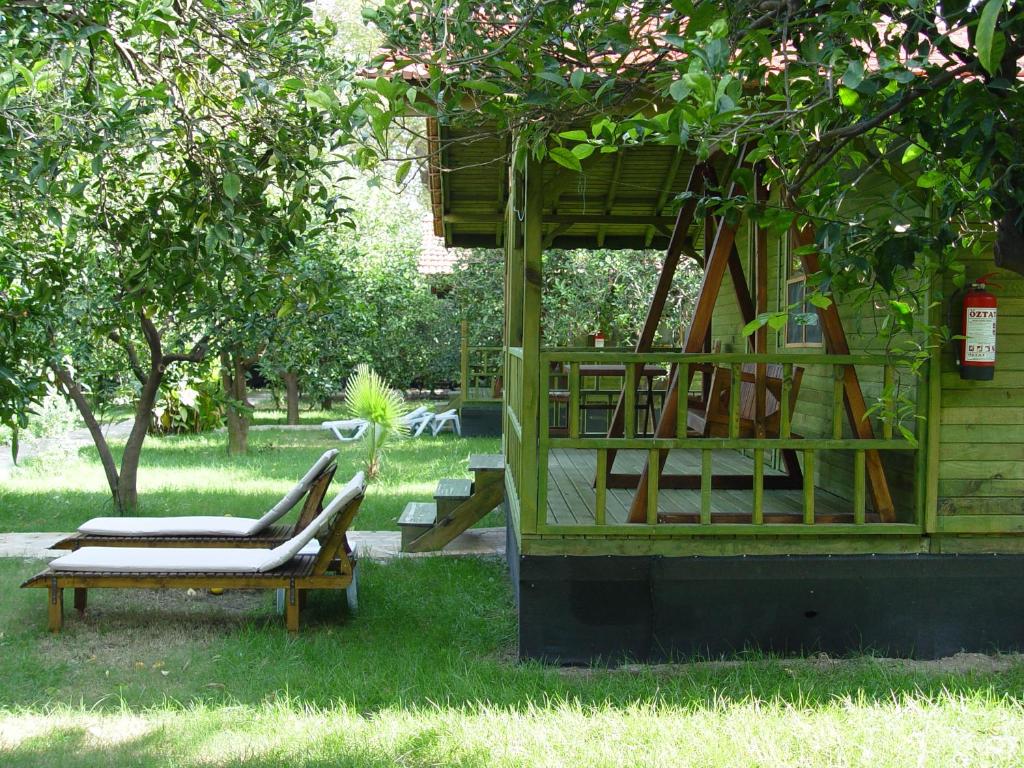 a group of chairs sitting under a tree at Hotel Yavuz Bungalow in Cıralı