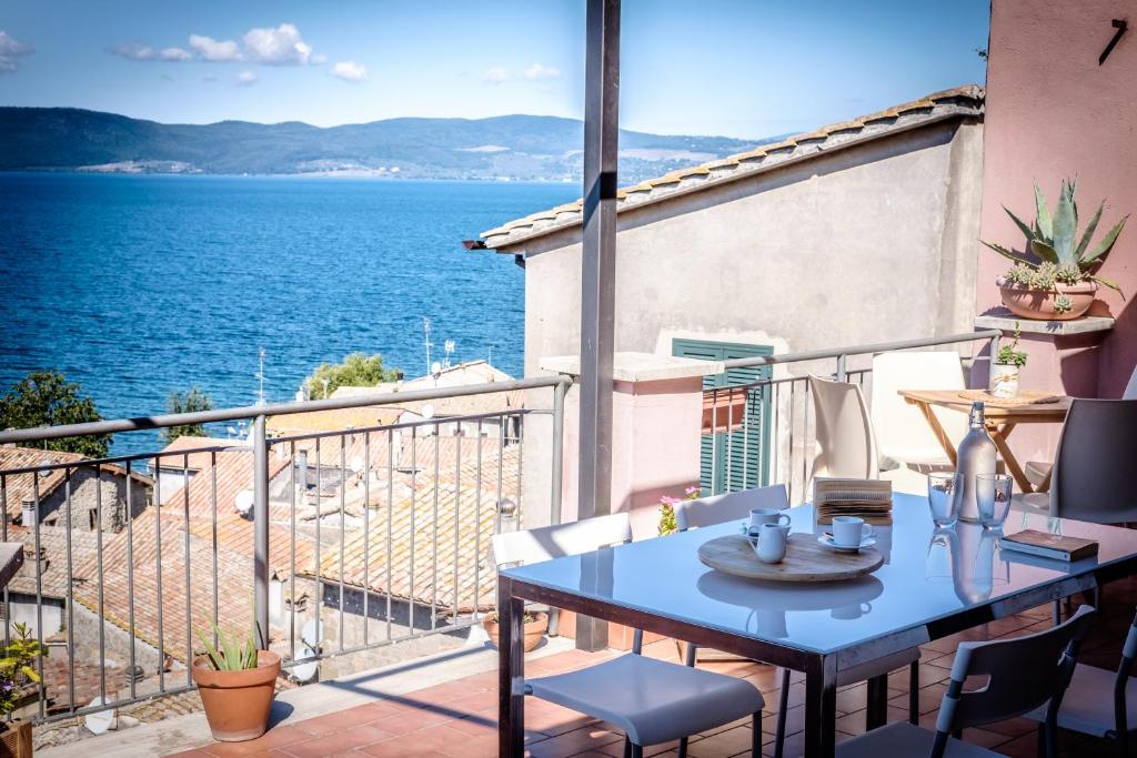 a balcony with a table and a view of the water at Domus Angularia in Anguillara Sabazia