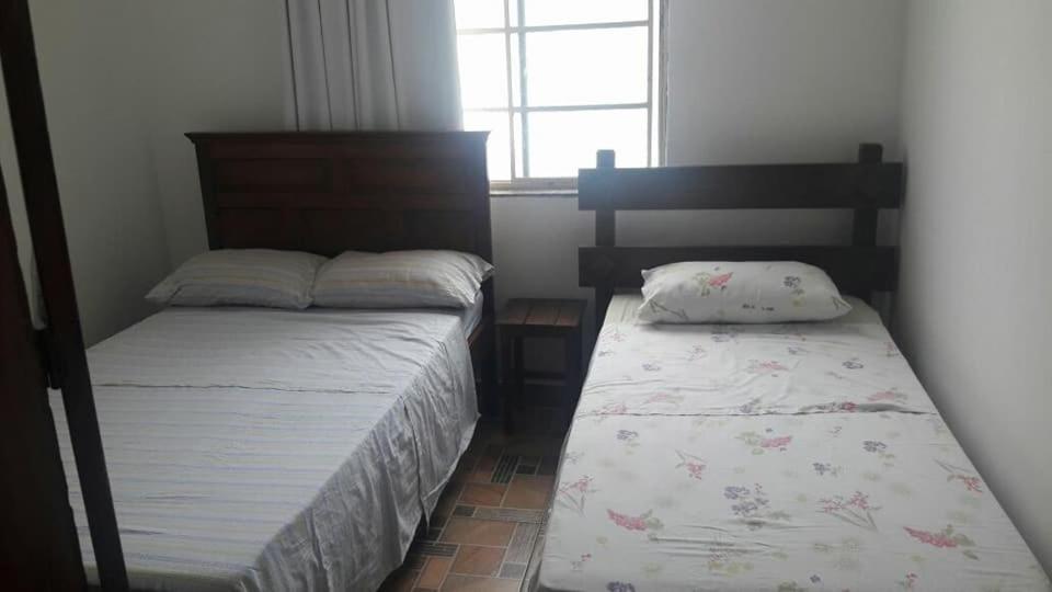 um quarto com 2 camas e uma janela em Casa da Tereza em Capitólio