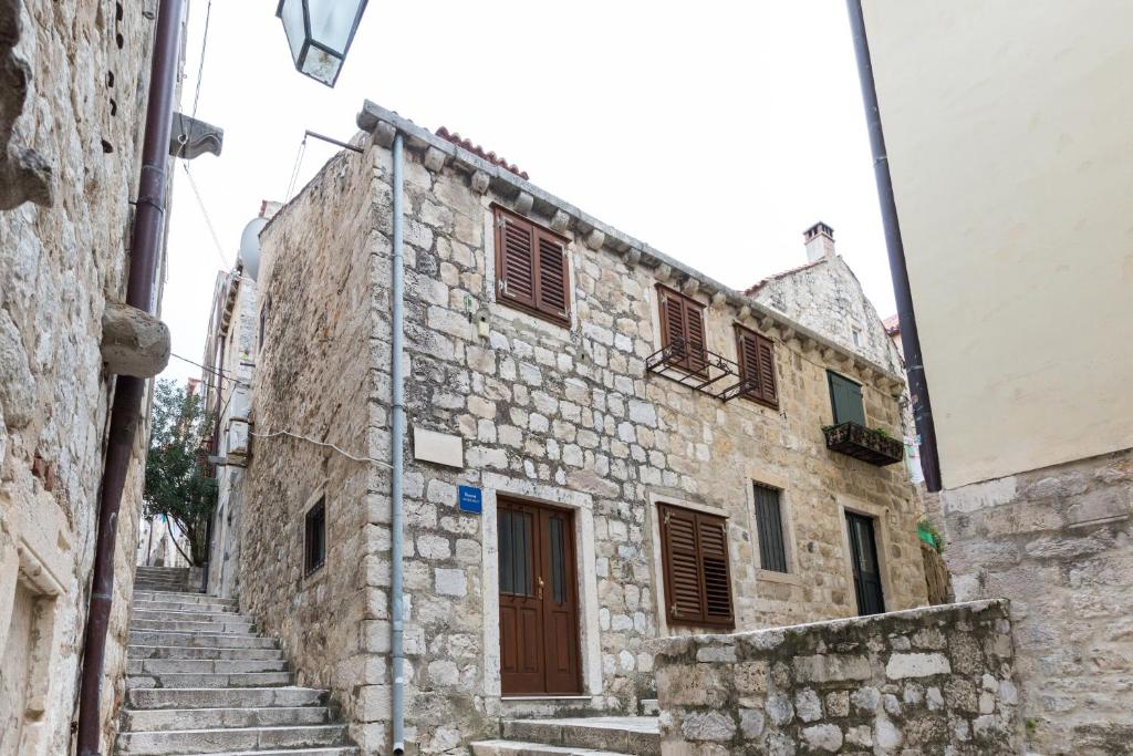 um antigo edifício de pedra com escadas num beco em Apartments Santa Maria em Dubrovnik