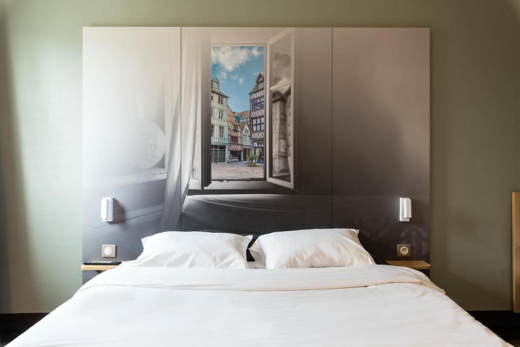 a bedroom with a large white bed with a window at B&B HOTEL Rouen Saint-Étienne-du-Rouvray in Saint-Étienne-du-Rouvray