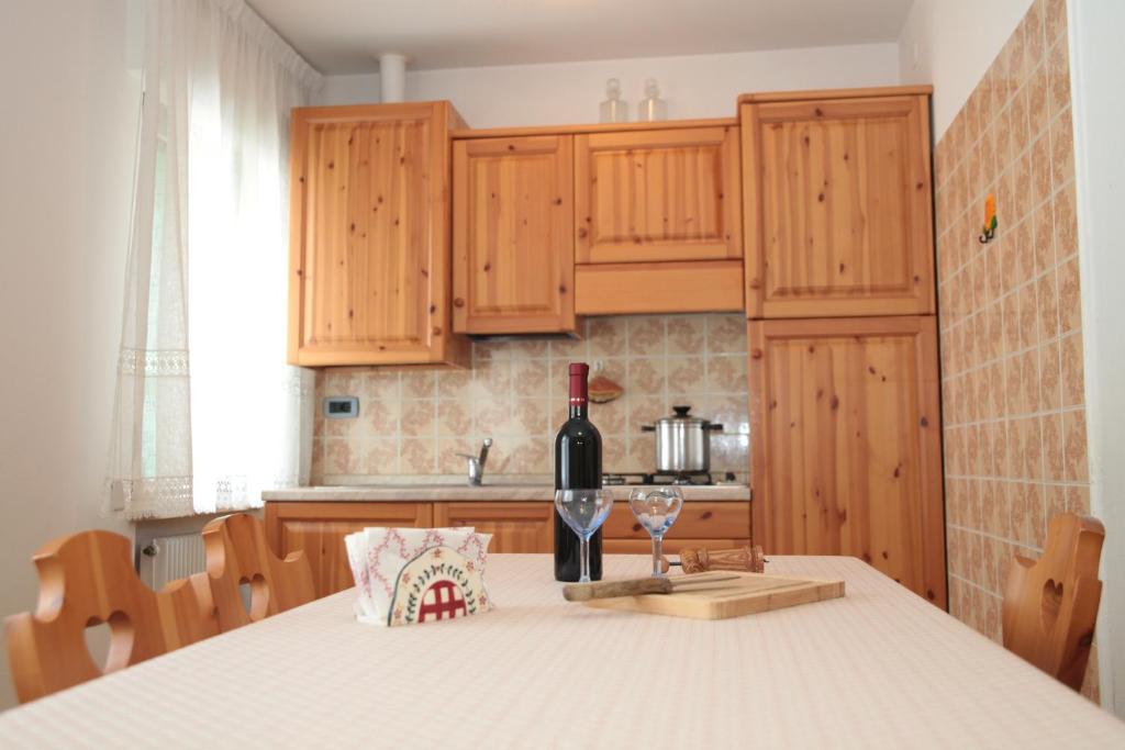 a bottle of wine sitting on a table in a kitchen at Albergo diffuso Valcellina e Val Vajont in Claut in Claut