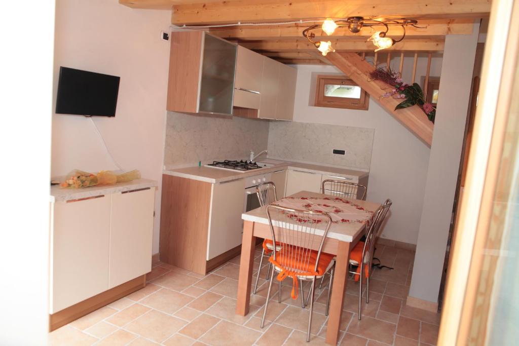 a kitchen with a table and chairs and a kitchen with a stove at Albergo diffuso Valcellina e Val Vajont in Claut in Claut