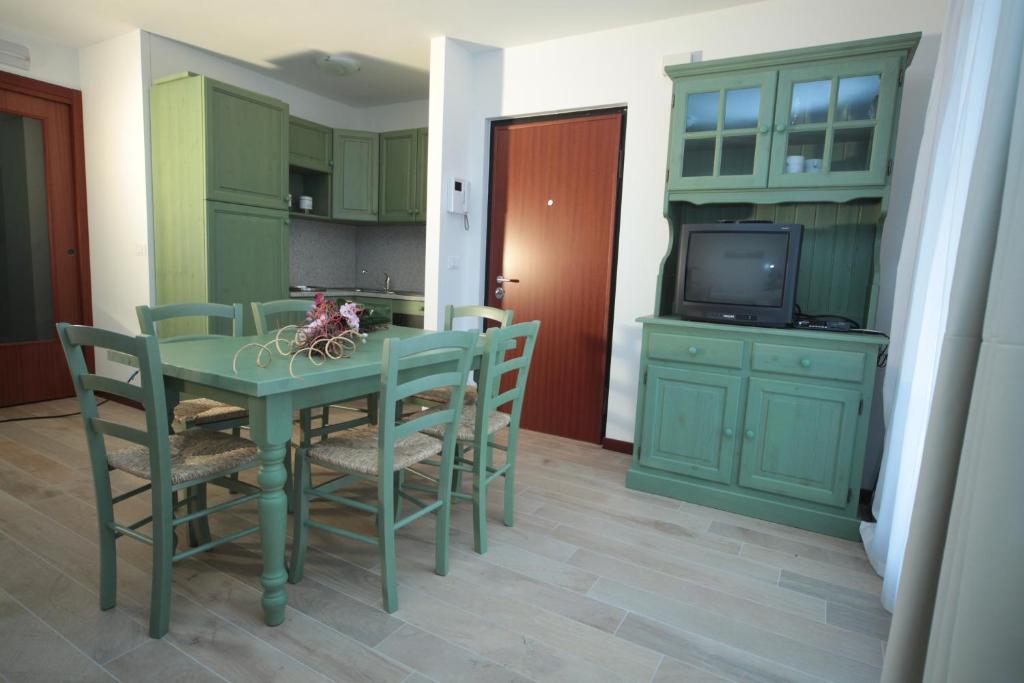 a kitchen with a green table and chairs and a tv at Albergo diffuso Valcellina e Val Vajont in Claut in Claut