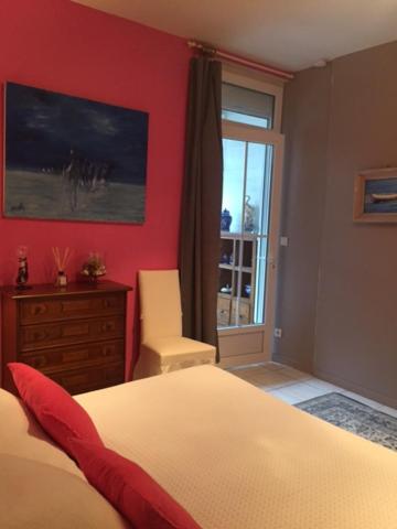 a bedroom with a bed and a dresser and a window at La Maison de Lilly in Arcachon