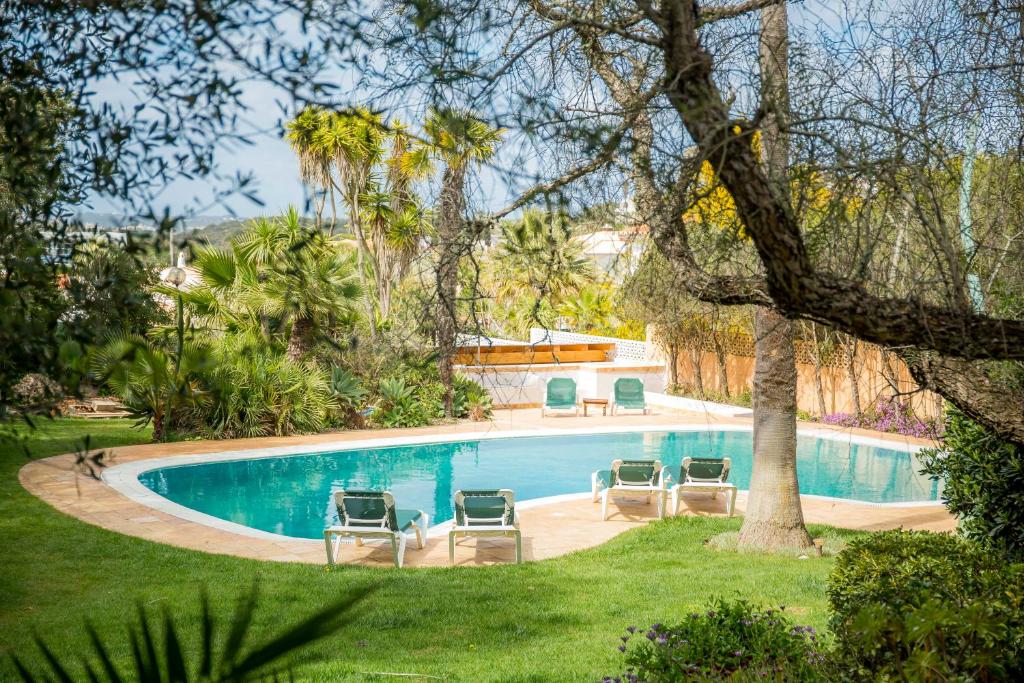 una piscina con 4 tumbonas en un patio en Casa da Montanha, en Luz