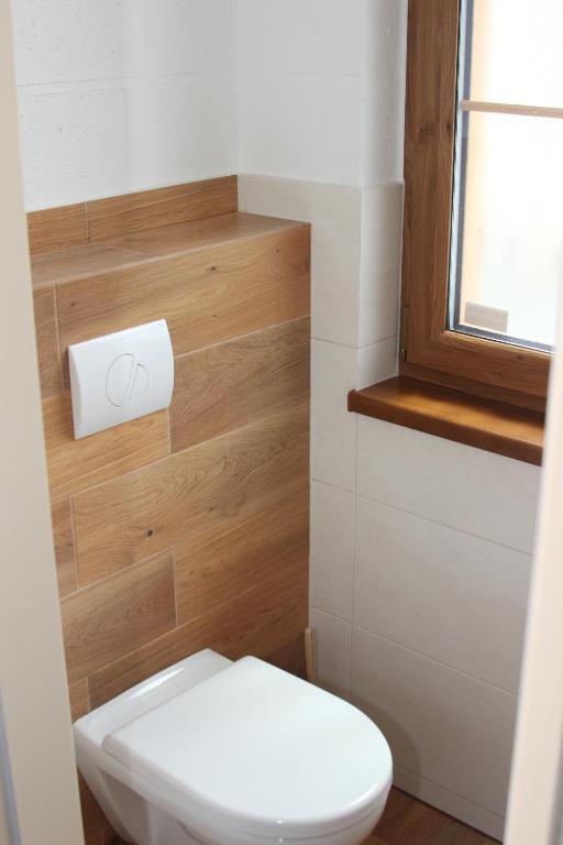 łazienka z białą toaletą i oknem w obiekcie Apartmány Loučná nad Desnou w mieście Loučná nad Desnou
