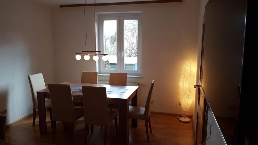 a dining room table with chairs and a window at Ferienwohnung am Hang in Ettenheim