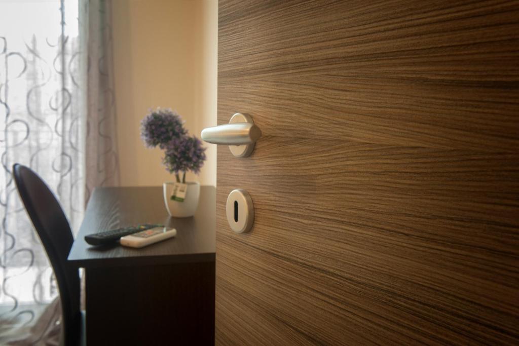 a room with a wooden door with a desk and a table with a table at Asaro Camere in Campobello di Licata