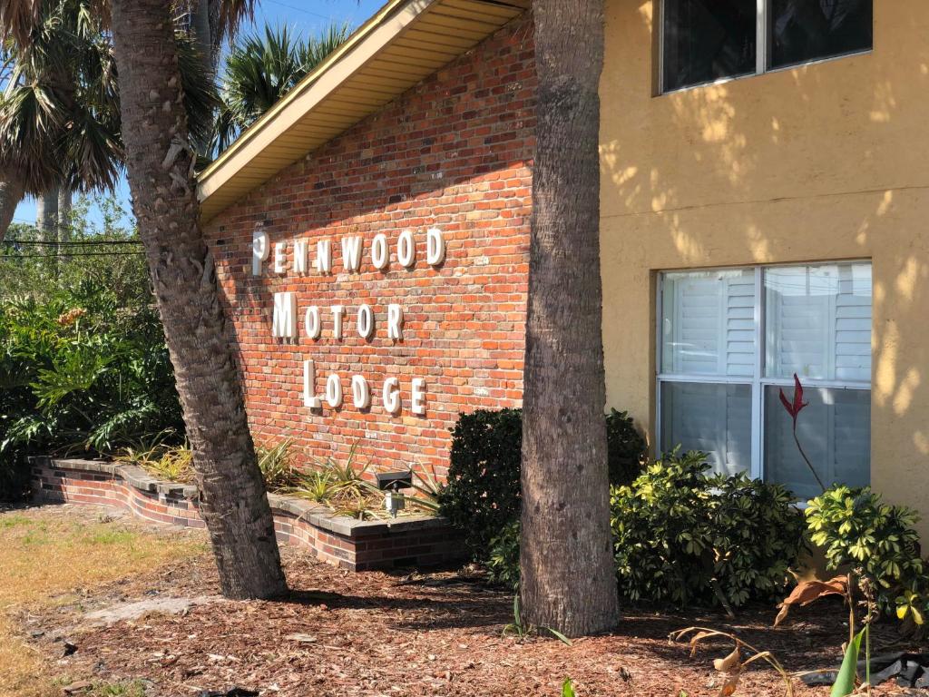 un edificio de ladrillo con un letrero que dice cabaña de motor encantada en Pennwood Motor Lodge, en Sebastian