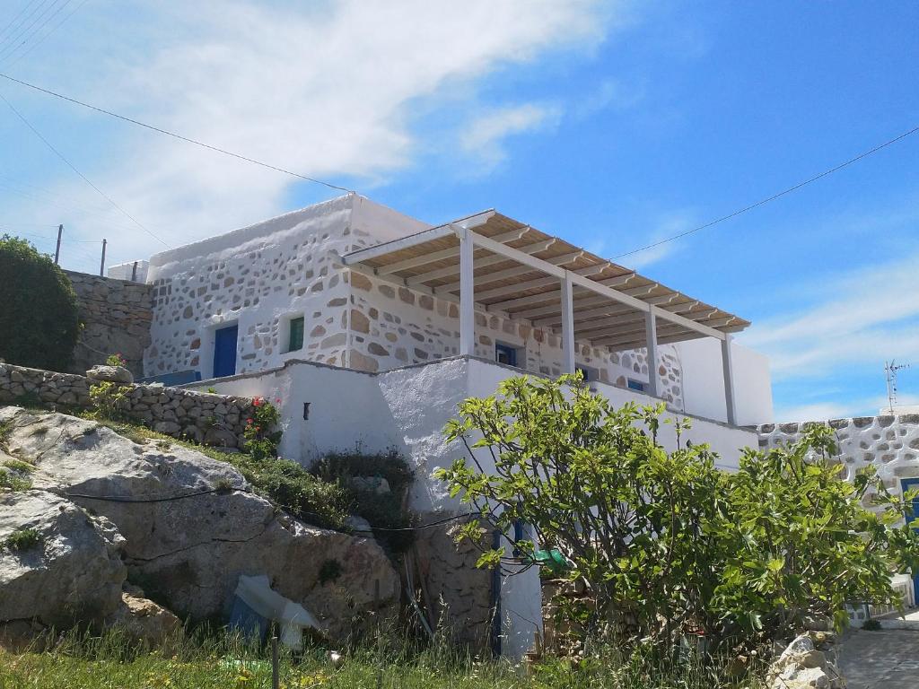 a house on a hill with rocks in front of it at Amazing View Dream House in Chora Folegandros