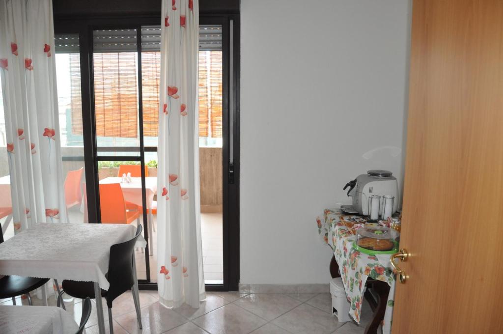 a room with a table and a kitchen with a window at Bed & Breakfast Oasi in Pescara